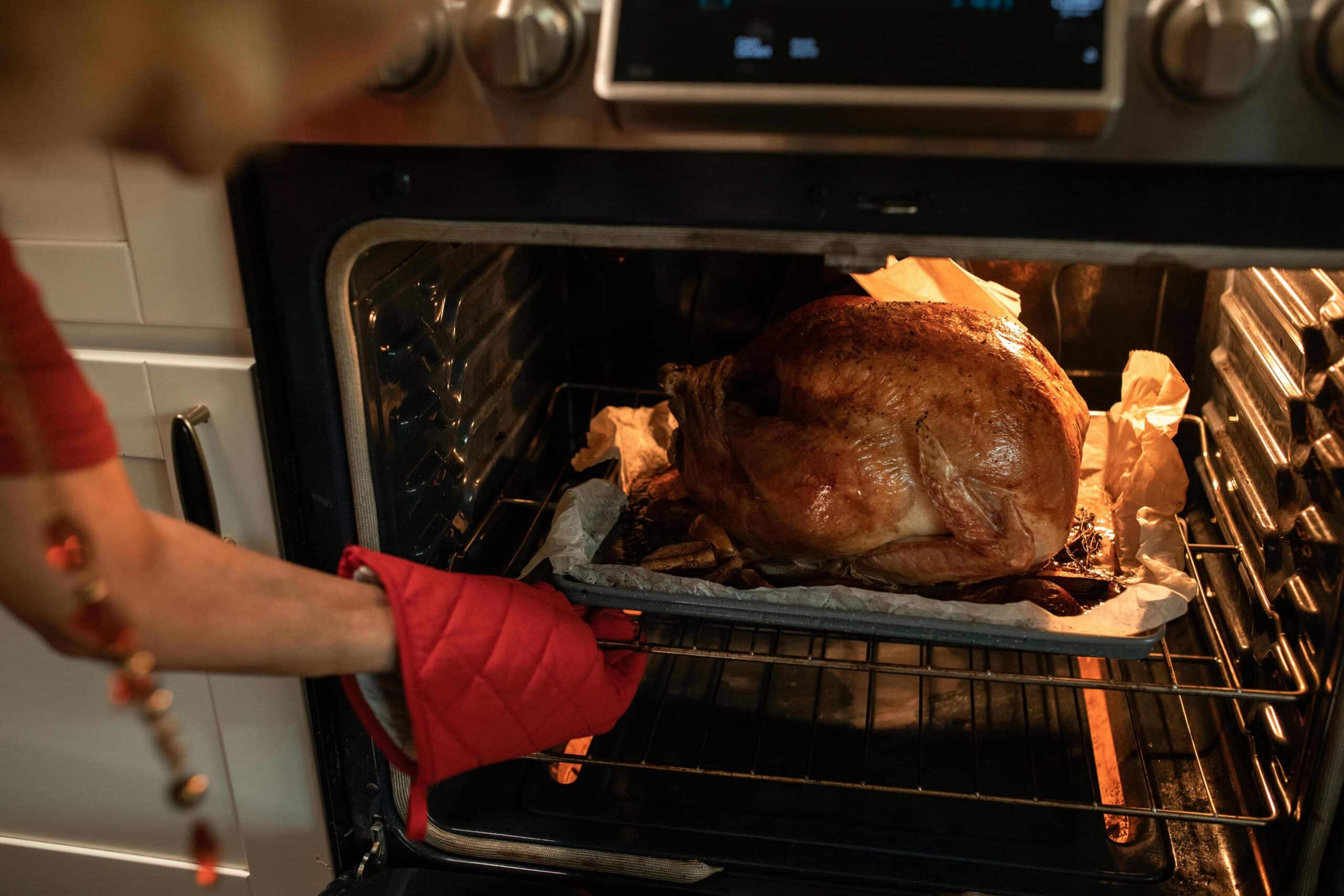 A woman roasting a turkey using leftover marinade.